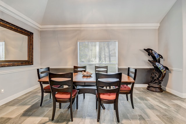 dining space featuring hardwood / wood-style floors, ornamental molding, and lofted ceiling