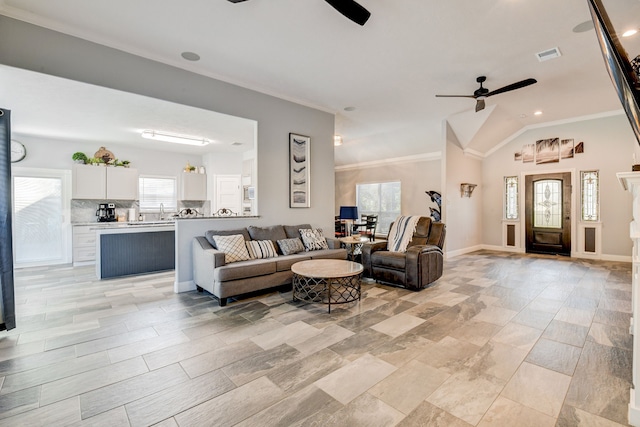 living room featuring lofted ceiling, crown molding, ceiling fan, and a healthy amount of sunlight