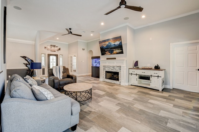 living room with crown molding, a fireplace, and ceiling fan