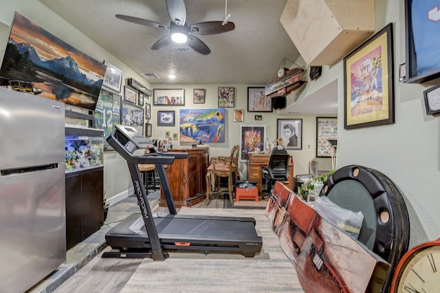 exercise area featuring bar, ceiling fan, and light wood-type flooring