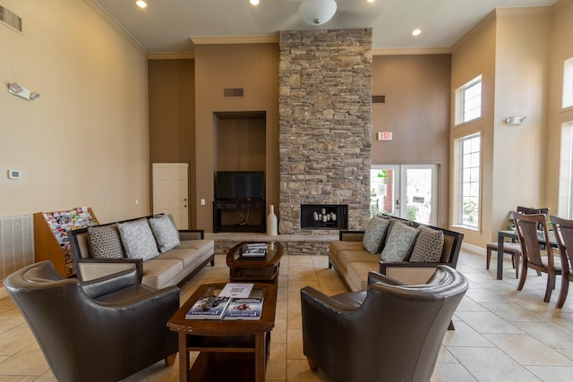 tiled living room with a fireplace, a high ceiling, and ornamental molding