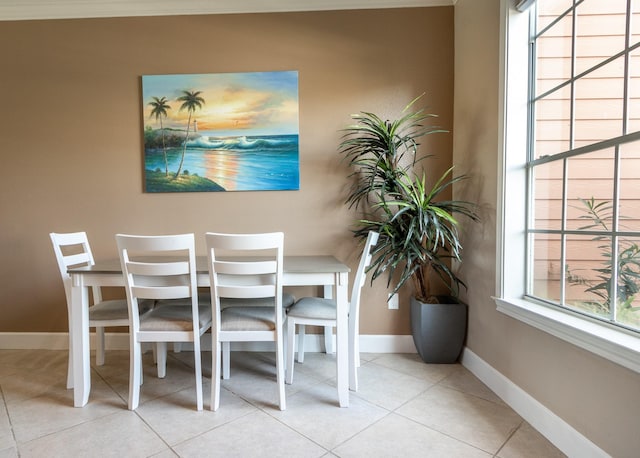 tiled dining space featuring crown molding