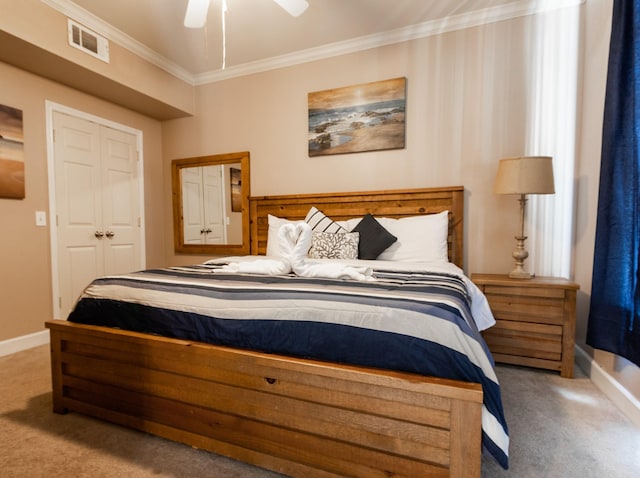 bedroom with crown molding, ceiling fan, a closet, and light colored carpet