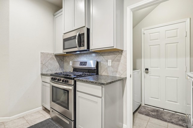 kitchen featuring appliances with stainless steel finishes, tasteful backsplash, light tile patterned floors, and white cabinetry