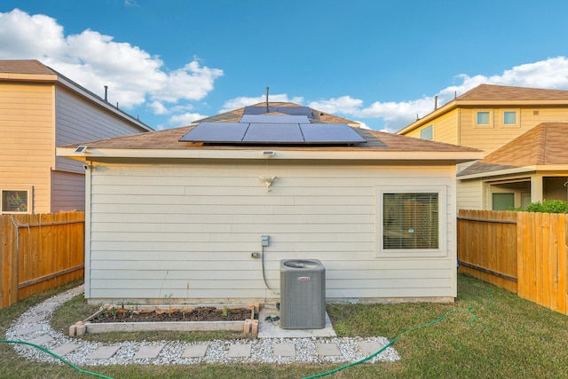 rear view of house with solar panels and central AC