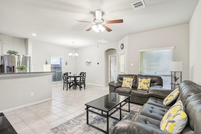 living room featuring light tile patterned floors and ceiling fan with notable chandelier