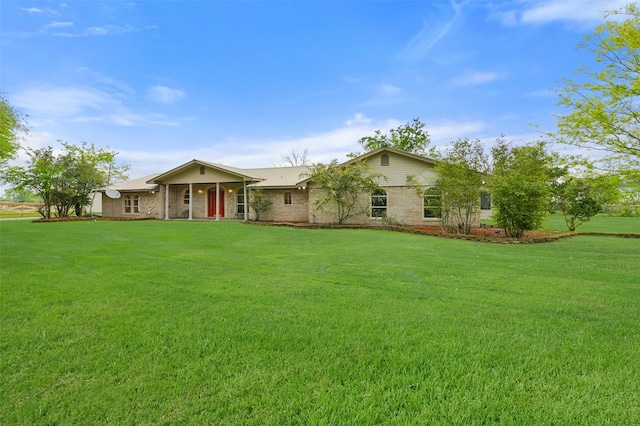 view of front facade with brick siding and a front yard