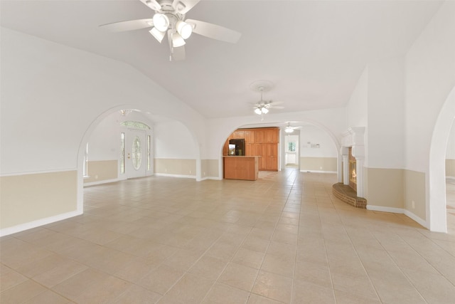 bonus room with arched walkways, baseboards, lofted ceiling, ceiling fan, and light tile patterned flooring