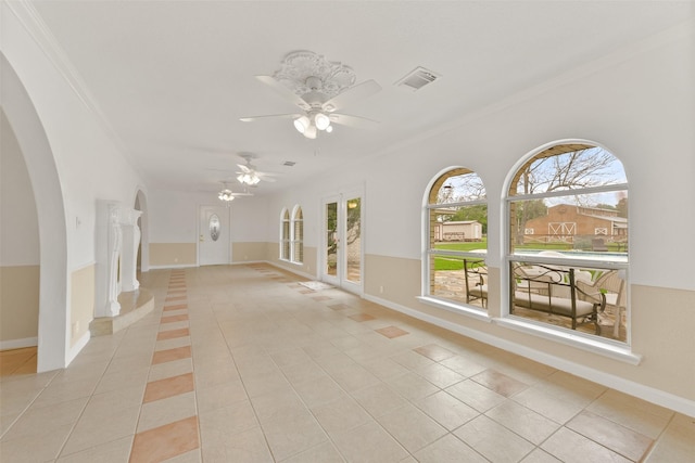 empty room with ornamental molding, visible vents, baseboards, and light tile patterned floors