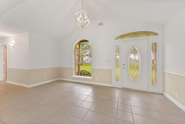 foyer with baseboards, visible vents, tile patterned floors, vaulted ceiling, and a chandelier