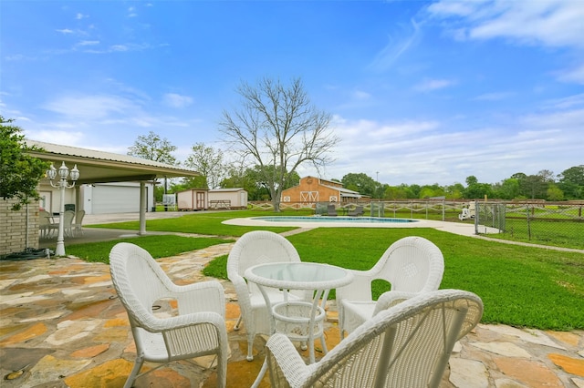 view of patio / terrace featuring an outbuilding, fence, and a fenced in pool