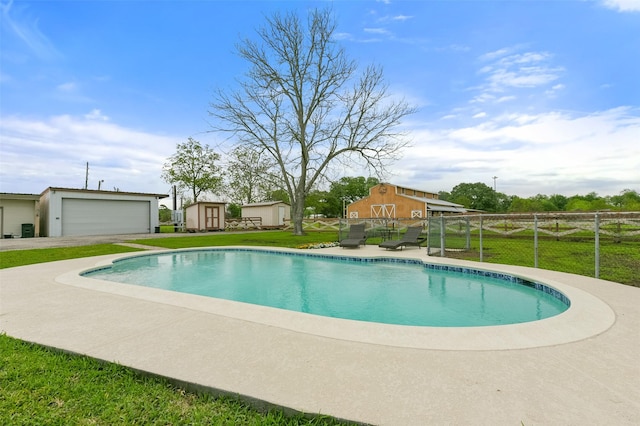 view of swimming pool featuring an outbuilding, a lawn, and fence