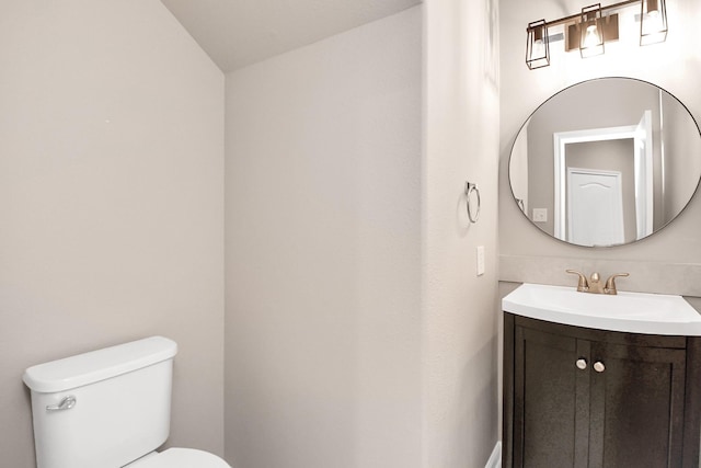 bathroom featuring vanity, toilet, and lofted ceiling