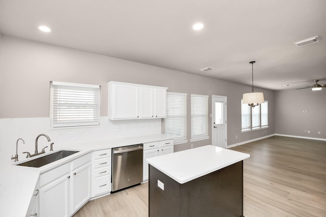 kitchen featuring dishwasher, white cabinets, a kitchen island, and sink