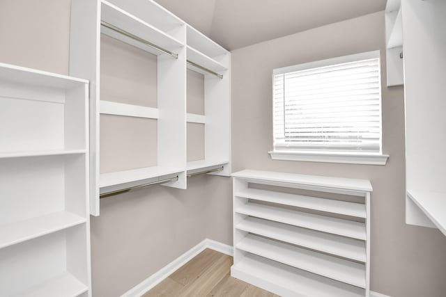 walk in closet with light hardwood / wood-style floors