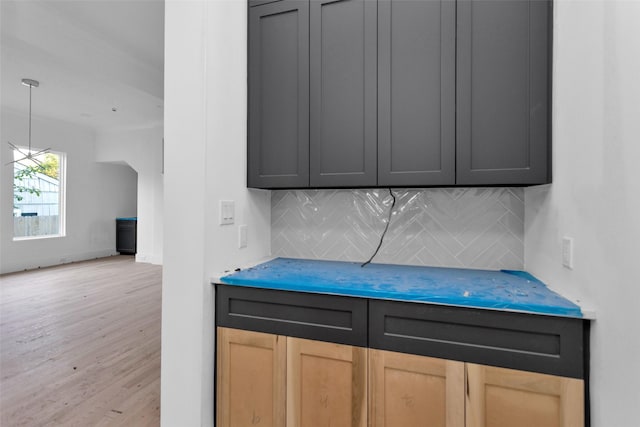 interior space with backsplash and hardwood / wood-style flooring