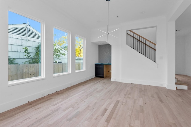 unfurnished living room with light wood-type flooring and ceiling fan