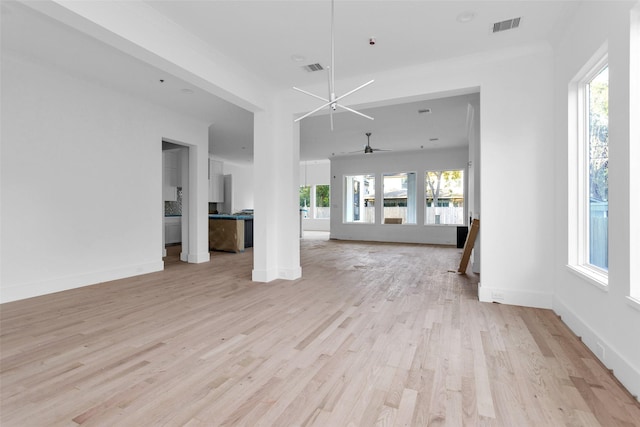 unfurnished living room with light hardwood / wood-style floors and ceiling fan with notable chandelier