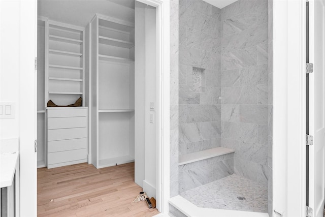 bathroom featuring tiled shower and hardwood / wood-style flooring