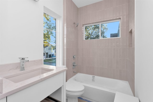 full bathroom featuring toilet, vanity, and tiled shower / bath combo