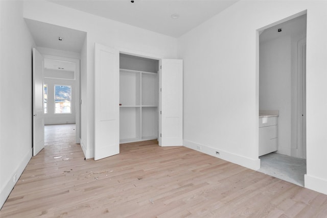 unfurnished bedroom featuring light hardwood / wood-style flooring and a closet