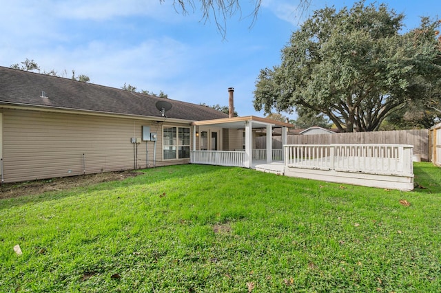 back of property featuring a deck and a yard