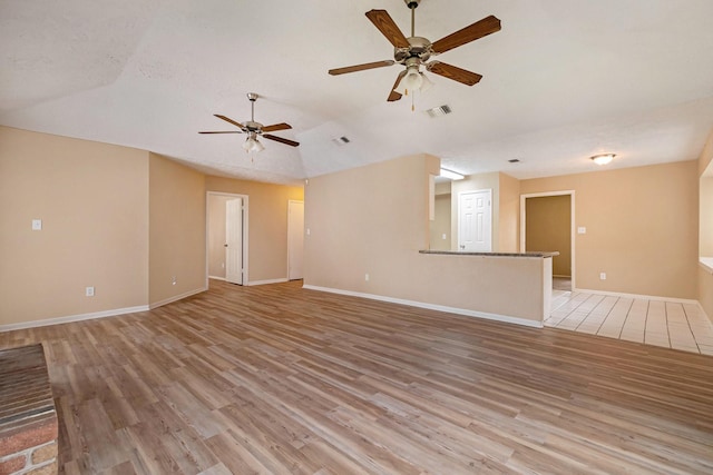 spare room featuring ceiling fan, light hardwood / wood-style floors, and lofted ceiling