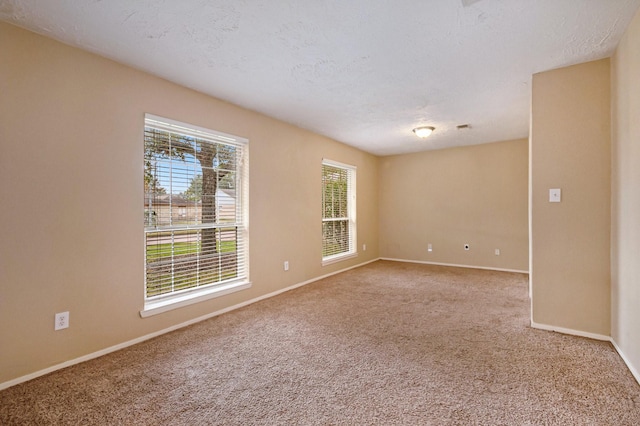 carpeted spare room with a textured ceiling