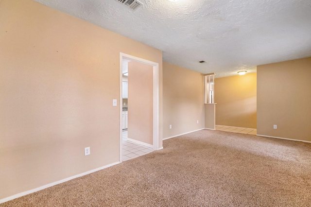 carpeted empty room with a textured ceiling