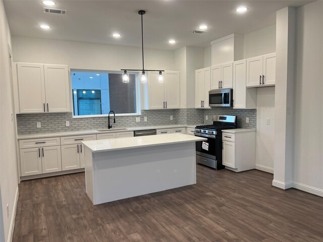 kitchen featuring white cabinets, decorative light fixtures, sink, and stainless steel appliances