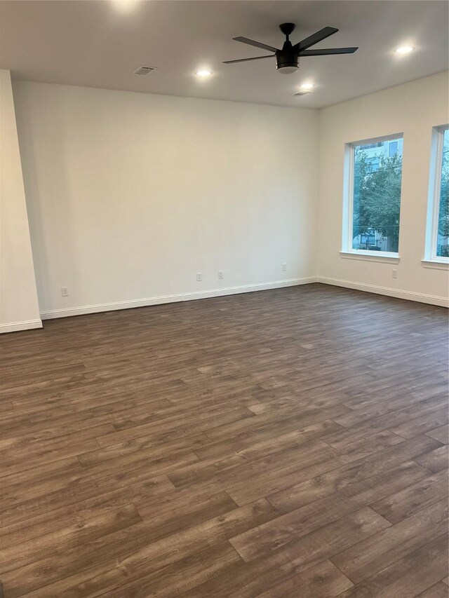 spare room featuring ceiling fan and dark wood-type flooring