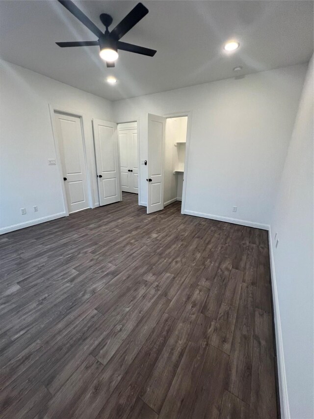 unfurnished bedroom featuring ceiling fan and dark wood-type flooring