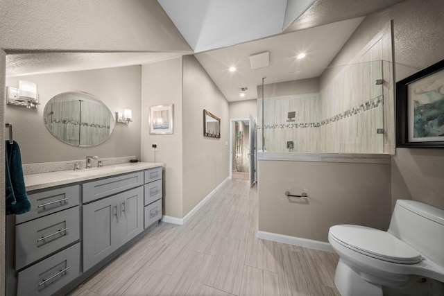 bathroom featuring a tile shower, vanity, and toilet