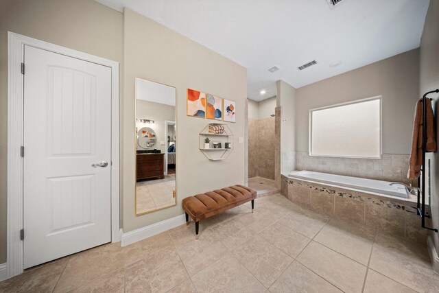 bathroom featuring tile patterned flooring and shower with separate bathtub