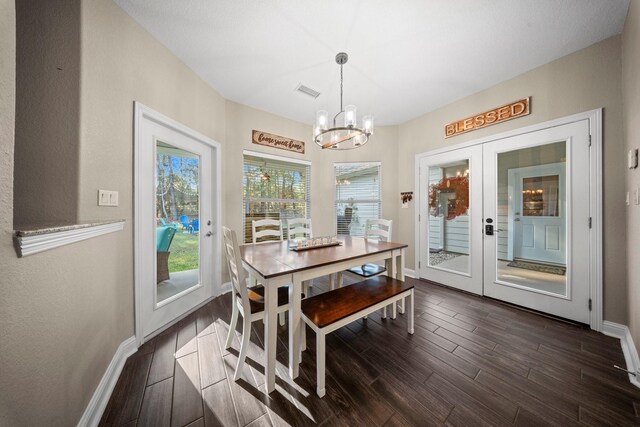 dining room featuring dark hardwood / wood-style flooring, french doors, and an inviting chandelier