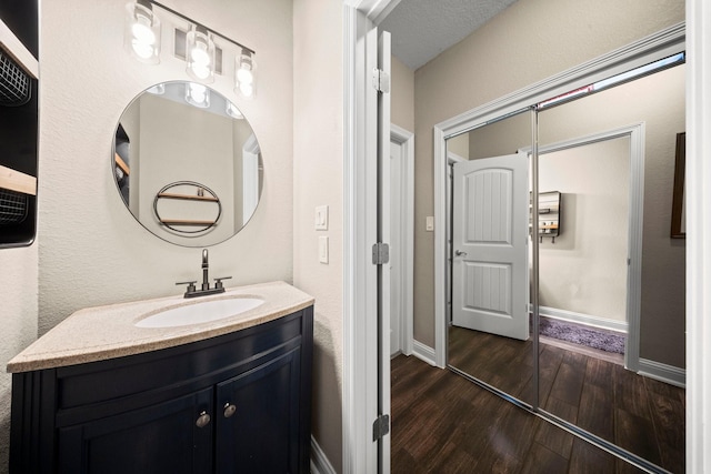 bathroom featuring a textured ceiling, vanity, and hardwood / wood-style flooring