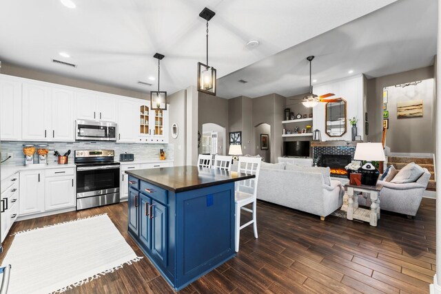 kitchen featuring blue cabinetry, stainless steel appliances, white cabinetry, and a kitchen island