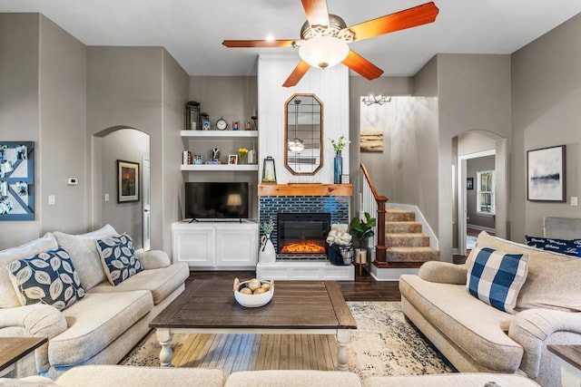 living room featuring ceiling fan, a fireplace, and hardwood / wood-style flooring