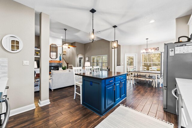 kitchen featuring blue cabinetry, a wealth of natural light, decorative light fixtures, and a fireplace