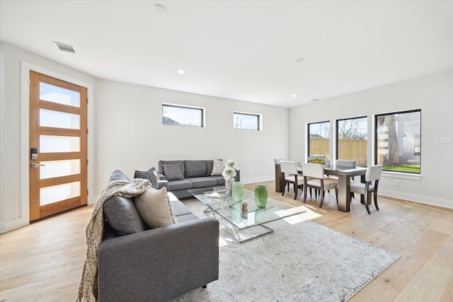 living room with recessed lighting, light wood-type flooring, visible vents, and baseboards