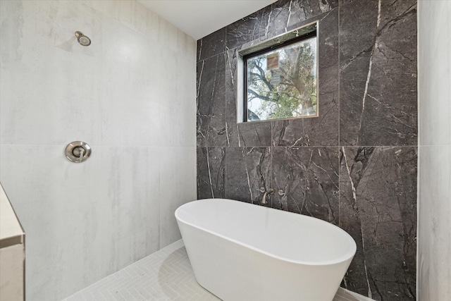 bathroom with a shower, a soaking tub, and tile walls