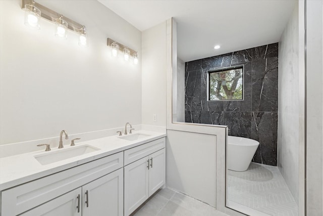 bathroom featuring tile patterned floors, a freestanding tub, a sink, and double vanity