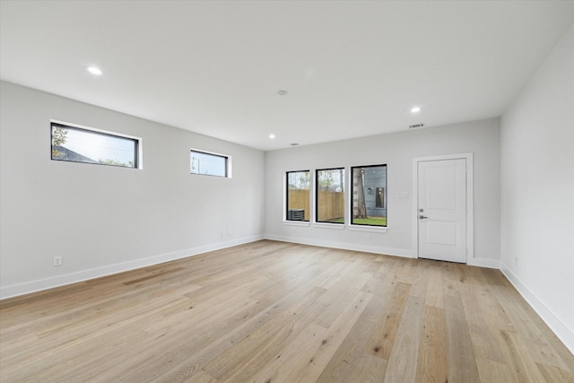 unfurnished room with light wood-type flooring, visible vents, baseboards, and recessed lighting