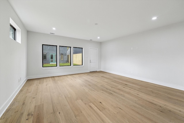 empty room featuring baseboards, visible vents, light wood-style flooring, and recessed lighting