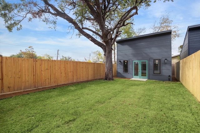 view of yard featuring french doors and a fenced backyard