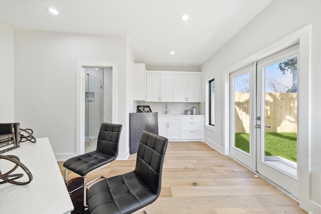 office space featuring french doors, light wood-type flooring, a sink, and recessed lighting