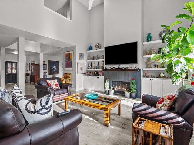 living room with light hardwood / wood-style floors and a high ceiling