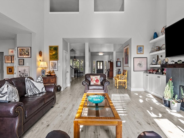 living room featuring a high ceiling and light hardwood / wood-style flooring