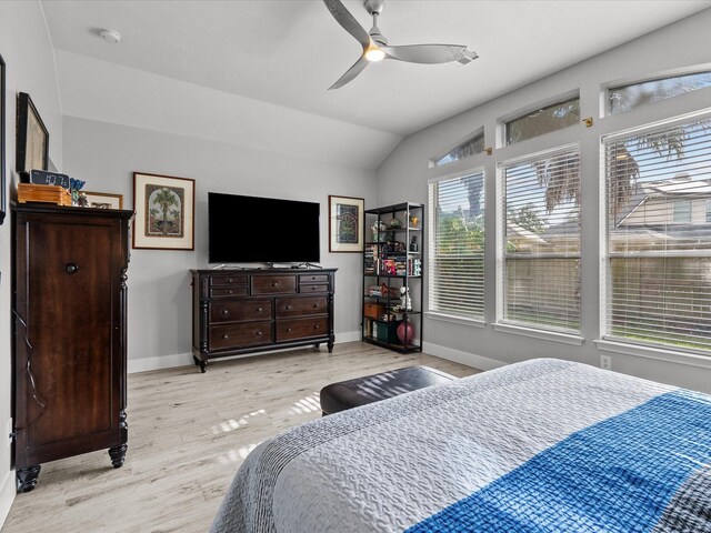 bedroom with ceiling fan, lofted ceiling, and light wood-type flooring