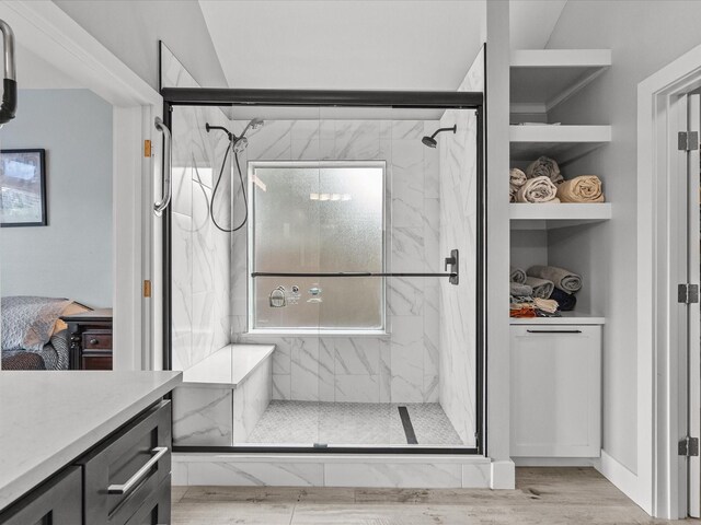 bathroom with walk in shower, vanity, vaulted ceiling, and hardwood / wood-style flooring